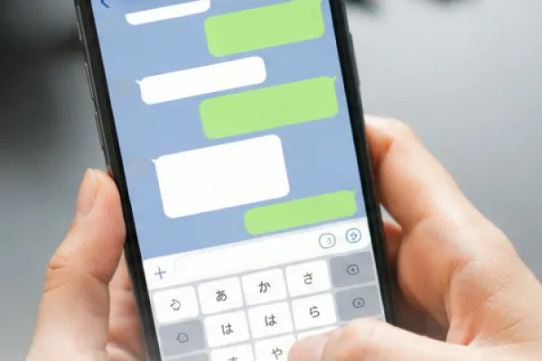 スマートフォンでメッセージを送る手元